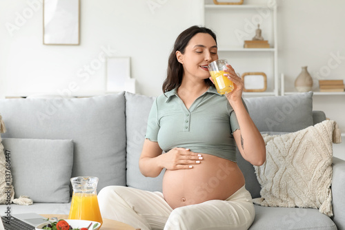Young pregnant woman drinki...