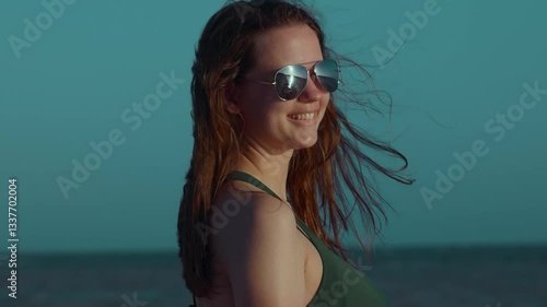 A young woman is enjoying a beautiful sunny day at the beach, fully embodying summer fun, joy, and confidence