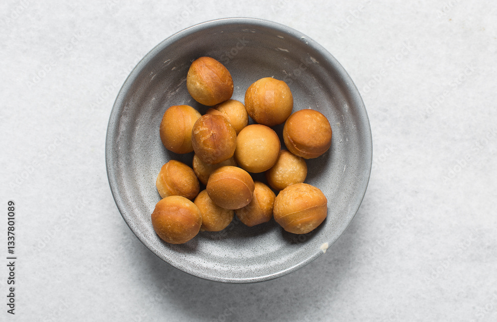 Overhead view of donut holes, top view of homemade doughnut holes on a white background, process of making doughnuts