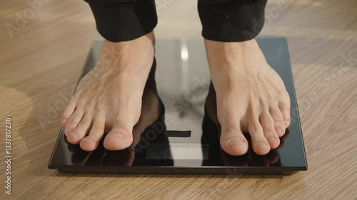 Close-Up of Barefoot Person Standing on Black Digital Scale with Measurement Display