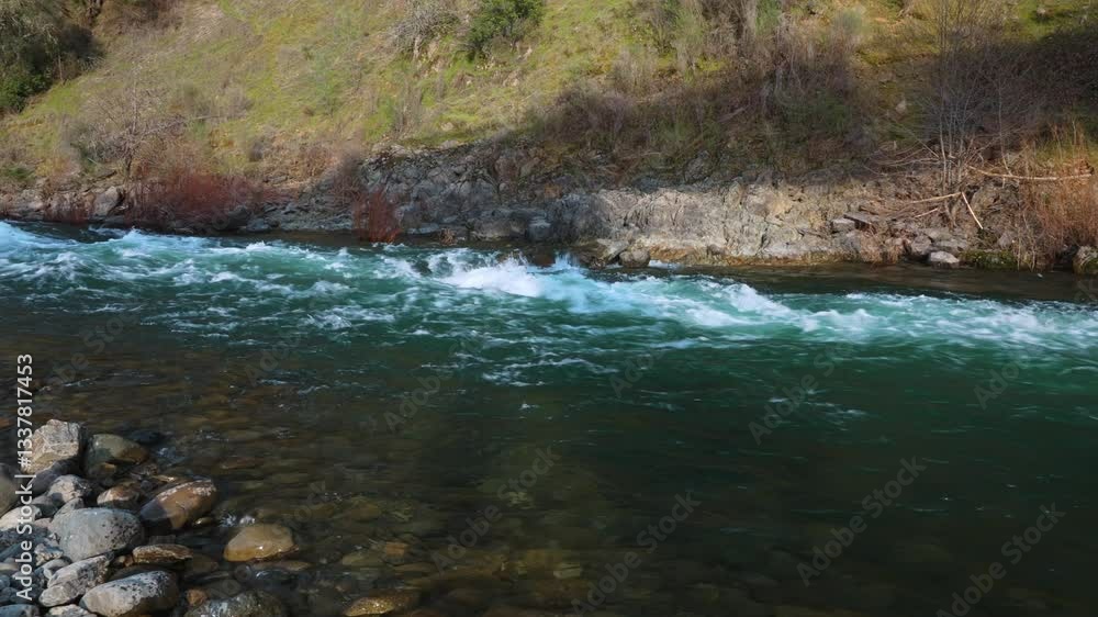 Rapid flow of a mountain river with turquoise water and a rocky shore
Rapid flow of a mountain river with turquoise water and a rocky shore