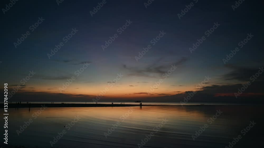 Idyllic twilight scene of coastline with peoples walking leisurely on the beach during low tide. Beautiful scenery of seascape during sunset with dramatic sky at Koh Samui, Thailand. Idyllic twilight scene of coastline with peoples walking leisurely on the beach during low tide. Beautiful scenery of seascape during sunset with dramatic sky at Koh Samui, Thailand.