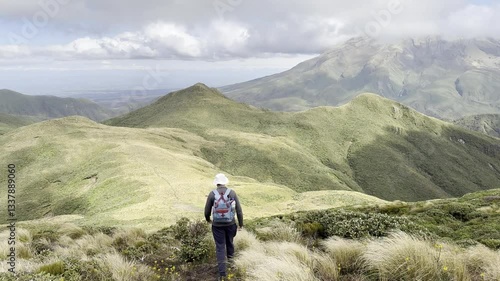 An adventurous man hikes on the picturesque Pouakai summit trail next the mighty Mount Taranaki volcano in Egmont National Park. Spectacular trails on north island, New Zealand. New Plymouth