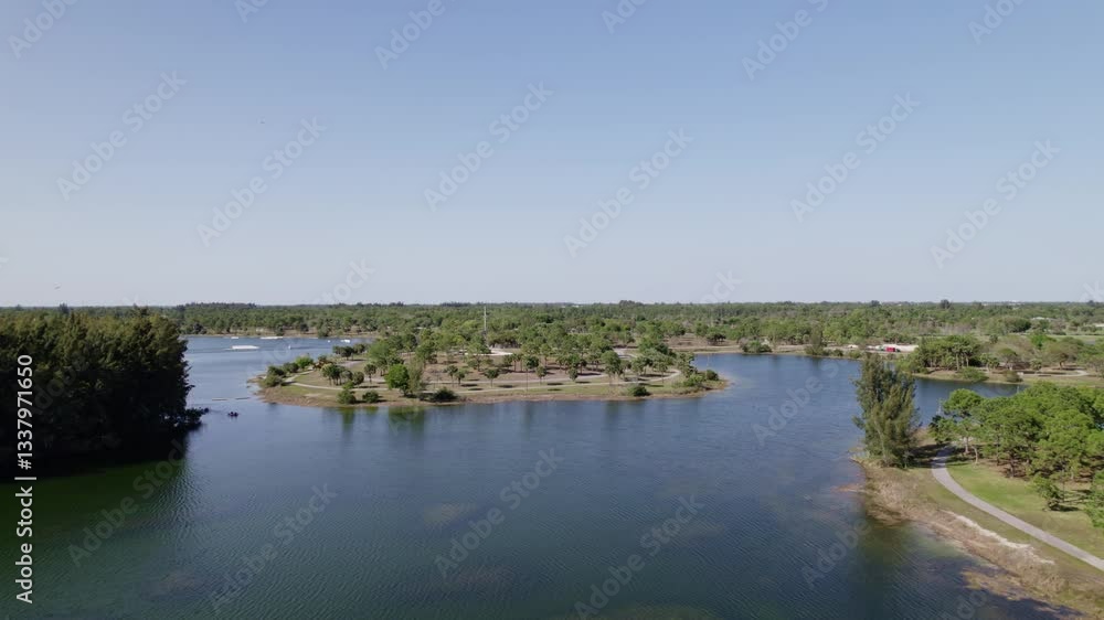 Establishing drone shot of lake in Okeeheelee Park during the day with sun shining and blue sky in West Palm Beach, Palm Beach County, Florida, USA Establishing drone shot of lake in Okeeheelee Park during the day with sun shining and blue sky in West Palm Beach, Palm Beach County, Florida, USA