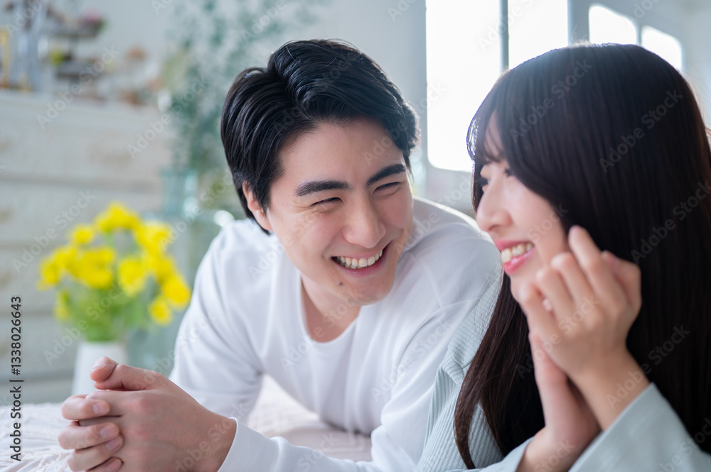 うつ伏せで笑顔の日本人男女
