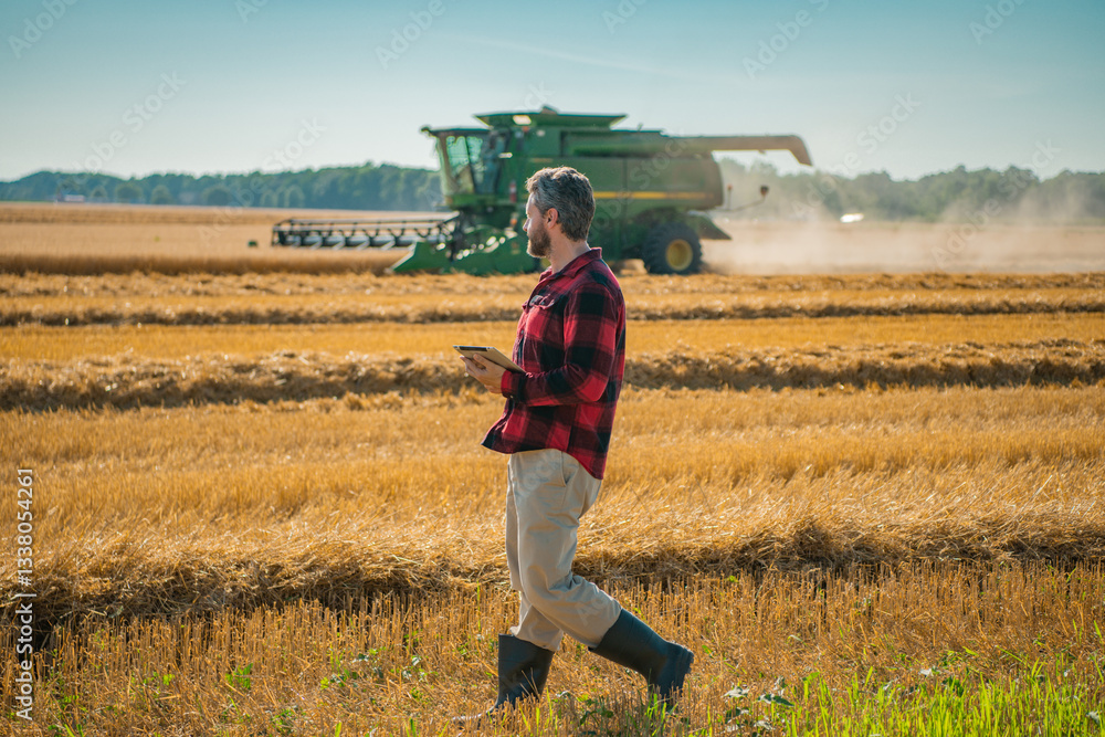 Fototapeta premium Portrait of american Farmer on wheat field. Farmer inspecting the harvest on farm. Wheat ready for farming. Farmer cultivated land. Farmer examining plant growth. Farmworker walking through the field.