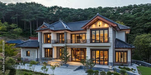 Large modern house with traditional roof in lush green hills