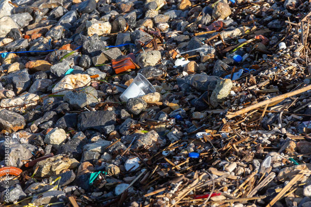 Plastic pollution on rocky beach highlighting environmental impact and need for conservation efforts. Plastic pollution on rocky beach highlighting environmental impact and need for conservation efforts.