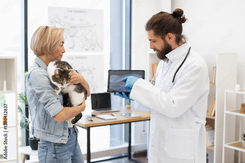 Fototapeta premium Veterinarian explaining X-ray image to young woman holding her pet cat indoors office. Image suitable for health care, veterinarian services, and animal welfare.
