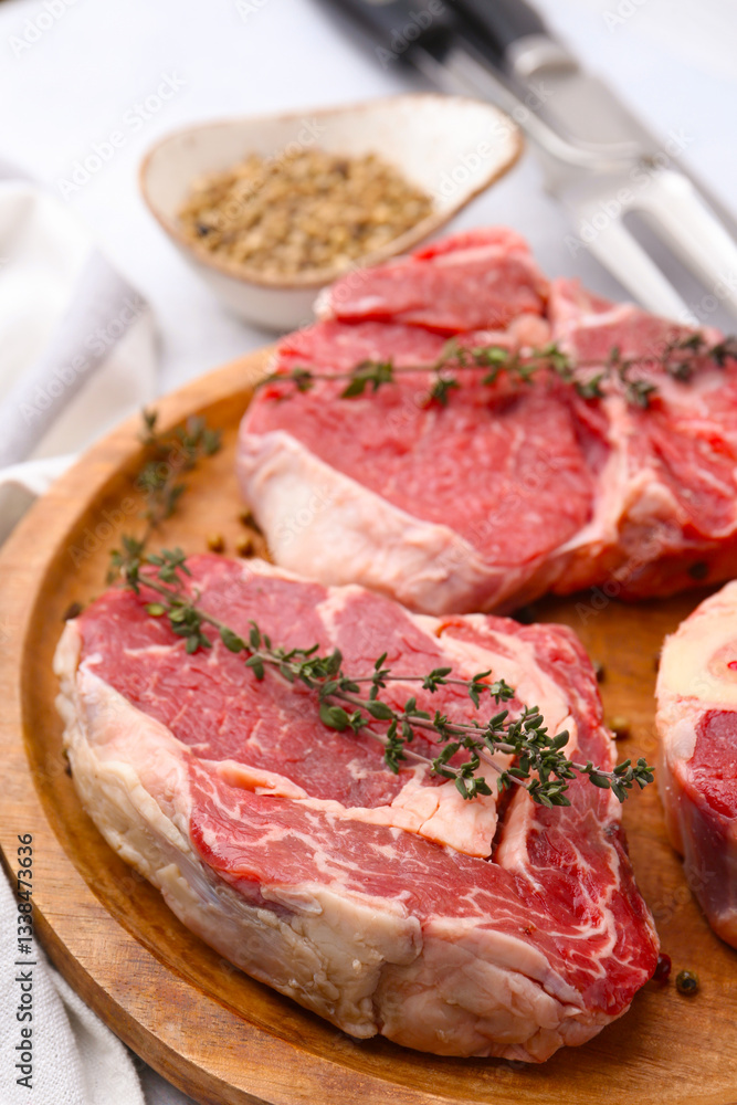 Pieces of raw beef and spices on light grey table, closeup Pieces of raw beef and spices on light grey table, closeup