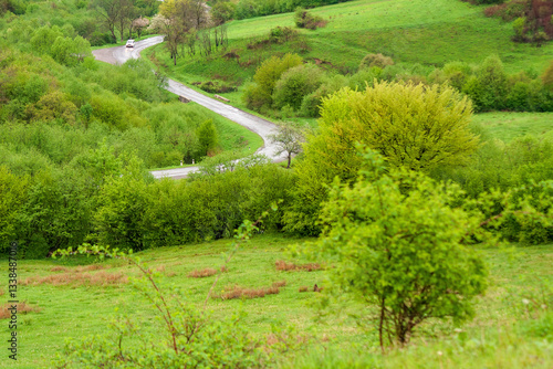 Obraz na płótnie travel landscape, with road through valley. green nature scenery in spring for tourism. beautiful rural background view from the hill with forest. outdoor adventure in the rain w salonie