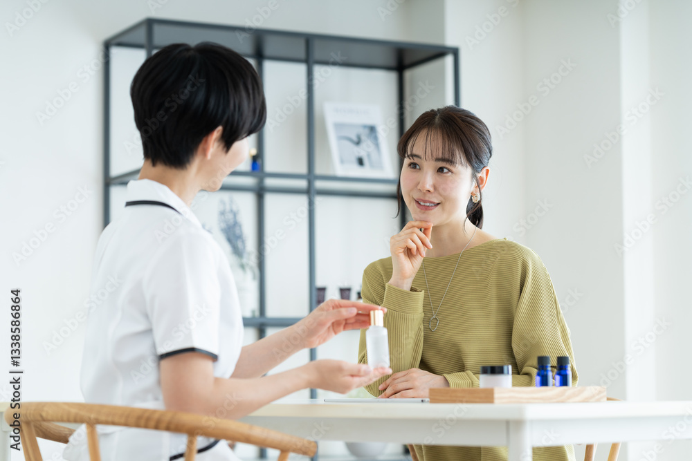 エステサロンで肌の相談をする若い女性 エステサロンで肌の相談をする若い女性