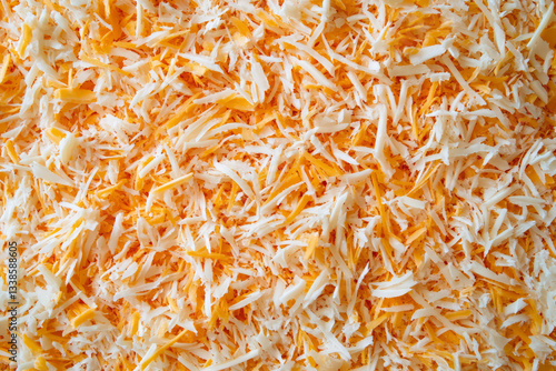 Close-Up of Freshly Grated White and Orange Cheese Texture Background

