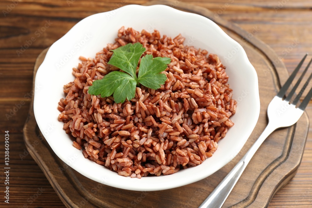Delicious brown rice with parsley served on wooden table, closeup Delicious brown rice with parsley served on wooden table, closeup