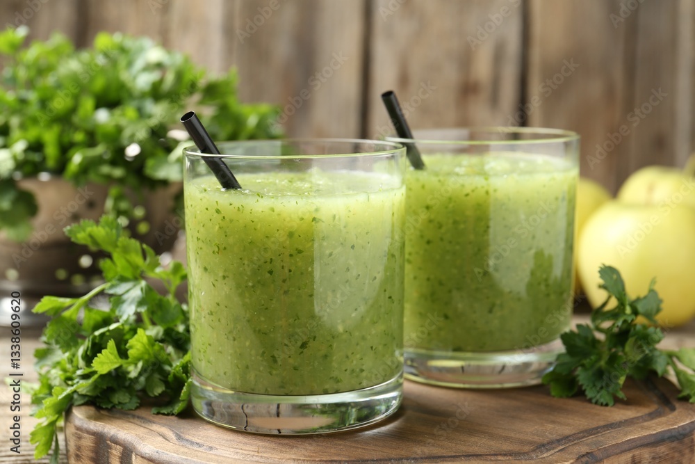 Healthy parsley smoothie in glasses and leaves on wooden table, closeup Healthy parsley smoothie in glasses and leaves on wooden table, closeup