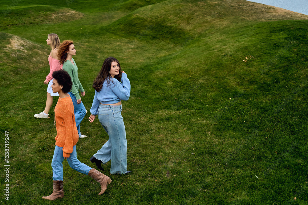 Obraz premium Four stylish women enjoying a lively spring day in a beautiful park setting