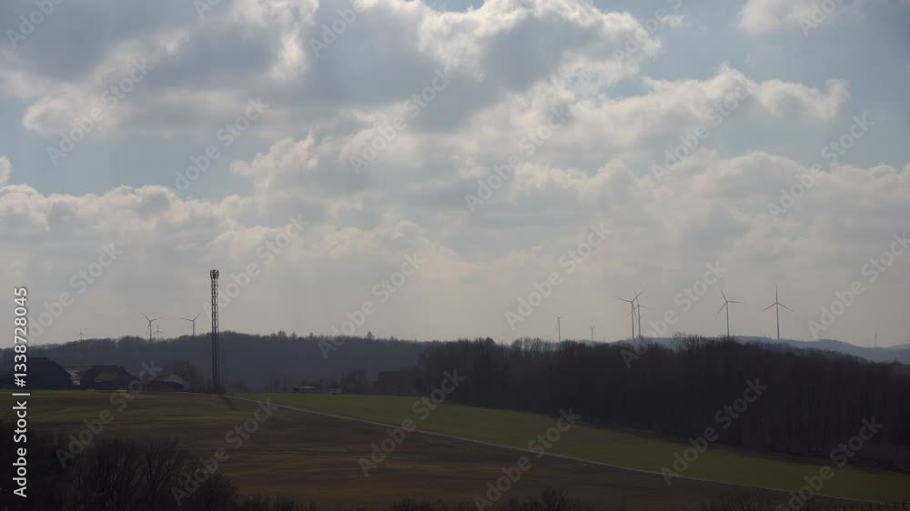 4K video of a wind farm on a hill against a blue sky with white clouds. Concept of green energy. 4K video of a wind farm on a hill against a blue sky with white clouds. Concept of green energy.