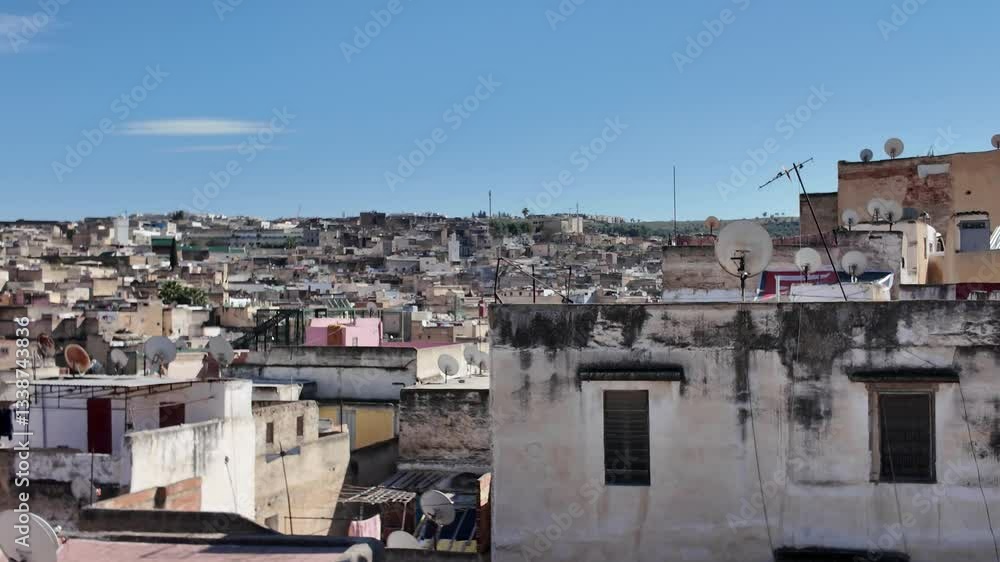 Cityscape of Fez featuring traditional buildings and vibrant rooftops under a clear blue sky, capturing the essence of Morocco's rich culture. Pan left Cityscape of Fez featuring traditional buildings and vibrant rooftops under a clear blue sky, capturing the essence of Morocco's rich culture. Pan left