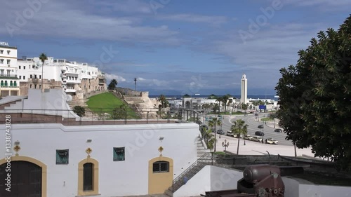 Wide establishing pan right over white walls and traditional Islamic architecture to Masjid Lalla Abosh in the distance, Tangier, Morocco