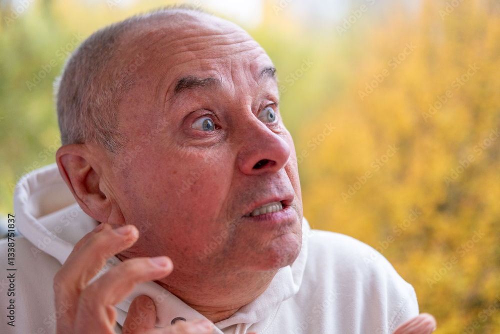 Obraz premium Angry older man with furrowed brow, intense gaze, and pursed lips. Serious senior man looking aggressive and upset, expressing strong emotions, Concept aggression, tension, and confrontation
