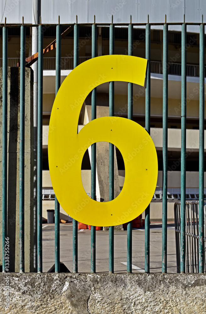 Number six in metal on metallic grid