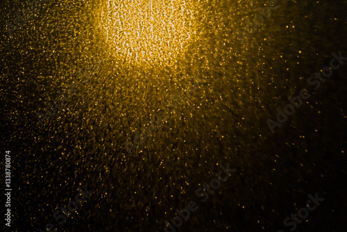 Blurred bokeh light sparkle on golden black background