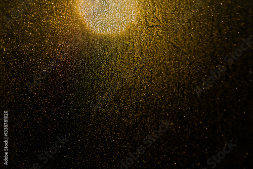 Blurred bokeh light sparkle on golden black background