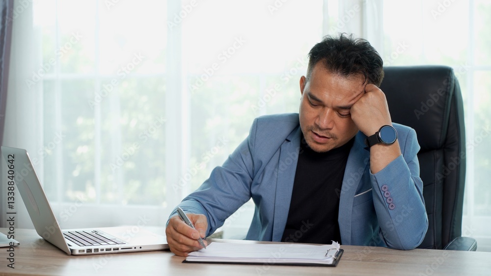 Naklejka premium Businessman working on laptop computer and documents on desk at office