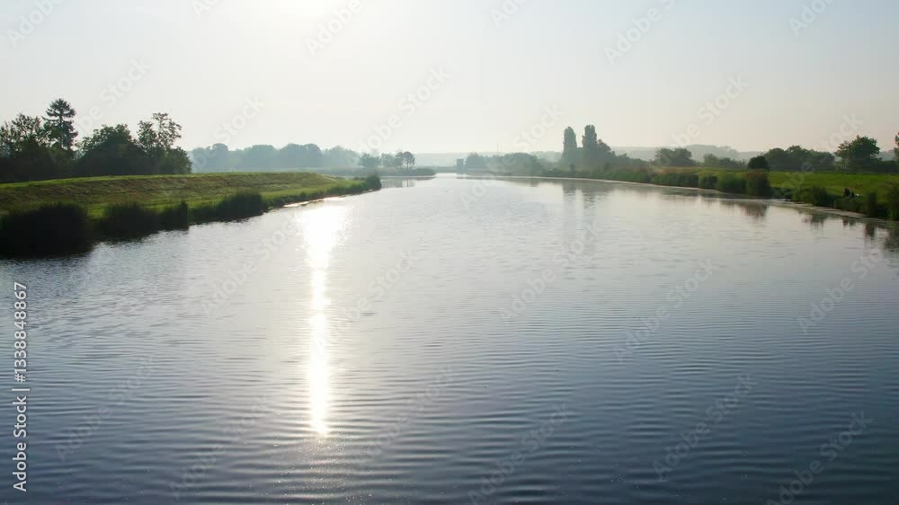 Serene river morning view with reflections and lush greenery in the background during sunrise Serene river morning view with reflections and lush greenery in the background during sunrise
