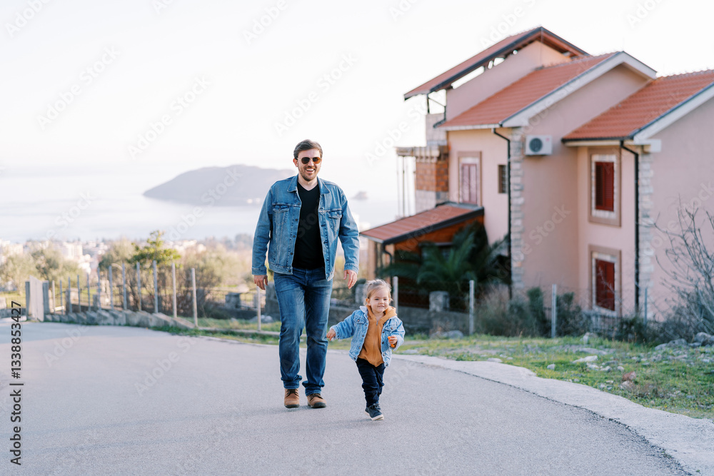 Dad follows a little girl up the road on a hill in a village above the sea Dad follows a little girl up the road on a hill in a village above the sea