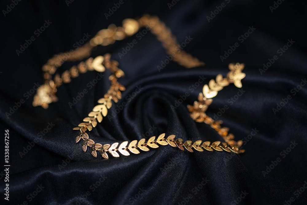 Fototapeta premium A close-up of a stunning leaf-patterned golden chain against a black background.