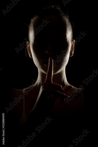 Cuadro en lienzo Mysterious silhouette of a woman making 'shh' gesture with finger on lips