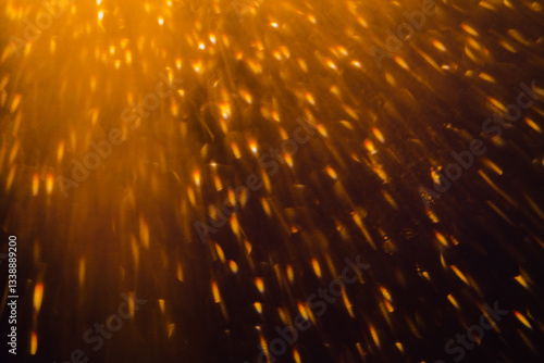 Blurred bokeh light sparkle on golden black background