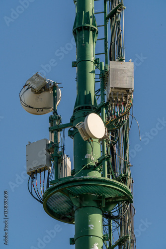 Communication tower stands tall against a bright blue sky, showcasing intricate technology and design in a serene landscape