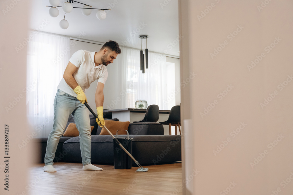 Fototapeta premium In domestic room. Male professional cleaning service worker