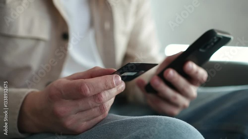 A person pays a receipt using a bank card. A man makes online purchases. Bank card in large plan. Shopping before the holidays. A person pays with a bank card. Man spending money