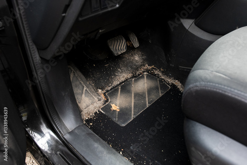 Sandy and dusty car floor mat by the pedals, showcasing the need for automotive cleaning. Great for vehicle maintenance, interior care, and detailing projects.