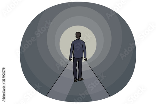 Man walks through dark tunnel towards exit, striving to achieve success and get out of problematic situation. Lonely guy sees light at end of tunnel, walking along mysterious path.