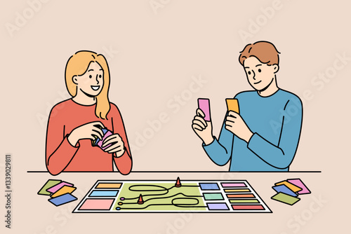 Happy couple playing board game while spending free time together and having fun after working day. Positive men and girl compete in board game, allowing them to get closer and improve mood