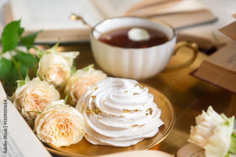 A cup of aromatic tea, a book and a rose on the table. A cup of aromatic tea, a book and a rose on the table.