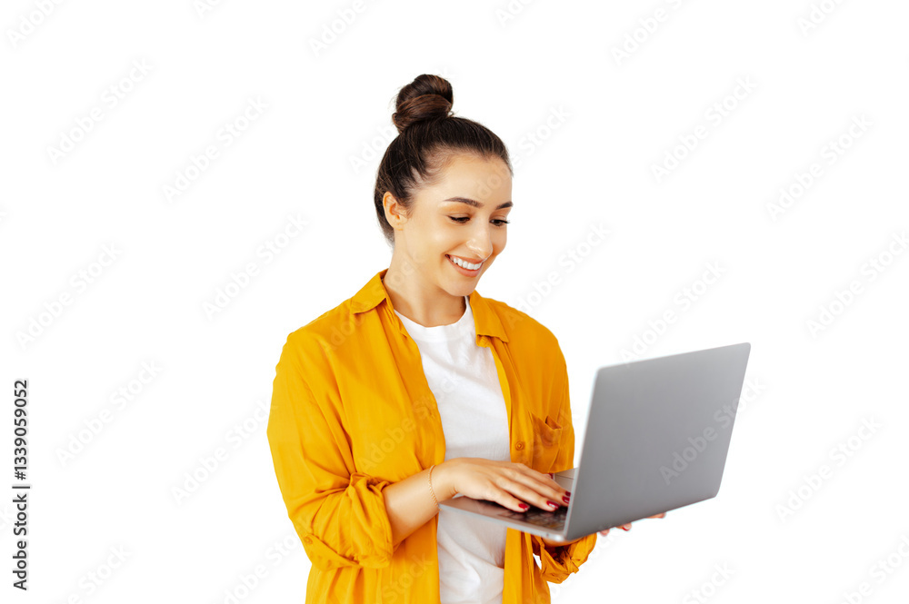 Happy caucasian woman in a casual yellow shirt types on a laptop while looking at the screen and smiles, she stands on isolated white background, symbolizing online work, and digital communication Happy caucasian woman in a casual yellow shirt types on a laptop while looking at the screen and smiles, she stands on isolated white background, symbolizing online work, and digital communication
