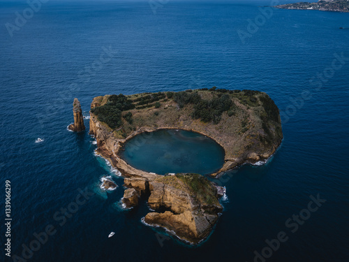 Obraz na płótnie A breathtaking aerial view of Islet of Vila Franca do Campo in the Azores, with its iconic circular lagoon, lush green cliffs, and the vast Atlantic Ocean. w salonie