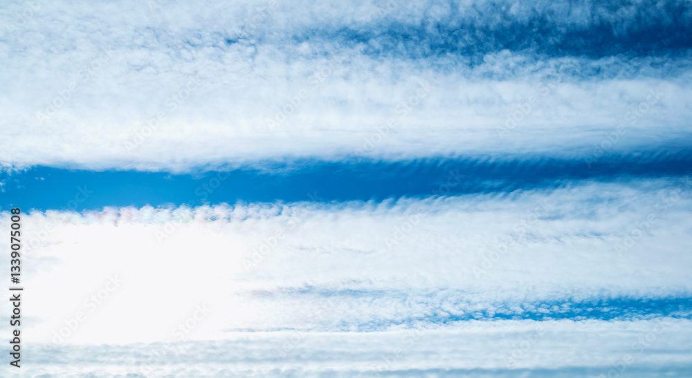 Obraz premium Dramatic blue sky background. Picturesque colorful clouds lit by sunlight. Vast sky landscape panoramic scene