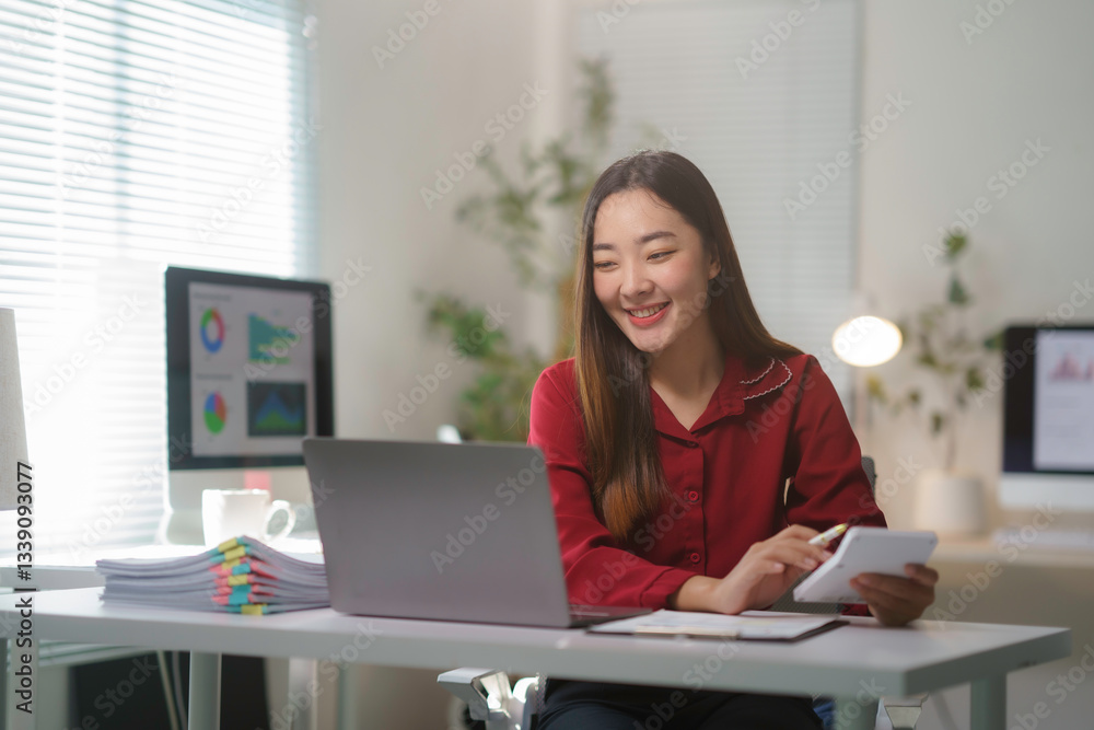 Professional woman calculating finances, working on laptop at contemporary workspace Professional woman calculating finances, working on laptop at contemporary workspace