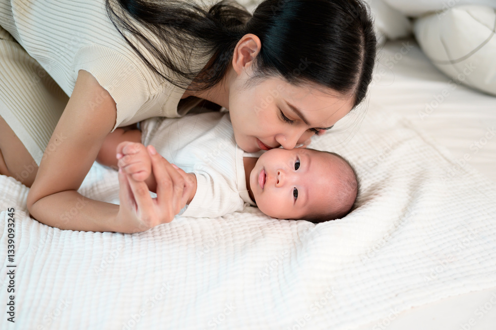 Mother Lovingly Interacts With Her Newborn Baby on a Cozy Bed in Natural Light Mother Lovingly Interacts With Her Newborn Baby on a Cozy Bed in Natural Light
