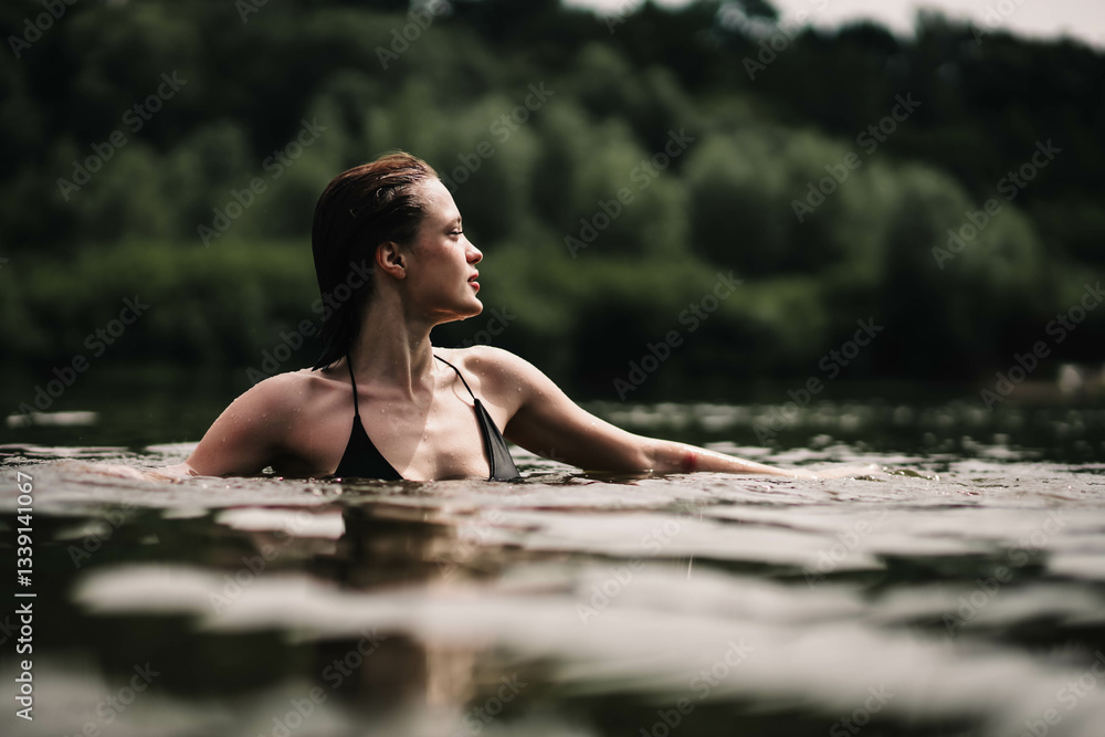 Fototapeta premium young woman swims in the pond and enjoys, rest in the lake river.