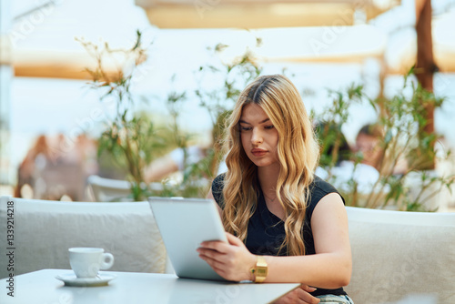 Businesswoman with Blonde Hair Sitting in a Caffee, Using a Tablet for Work. Free Download Businesswoman with Blonde Hair Sitting in a Caffee, Using a Tablet for Work. - GFXLoad