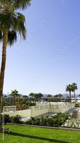 Panoramic video view of a Luxury hotel resort from the nice terrace with palm trees, mountains, oriental architecture. Sunny vacations in Egypt