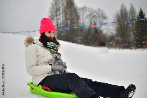 Obraz na płótnie Girl sledding downhill on snow in winter and laughing with joy w salonie