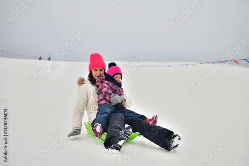 Obraz na płótnie Two girls are tobogganing downhill on snowy hill in winter w salonie